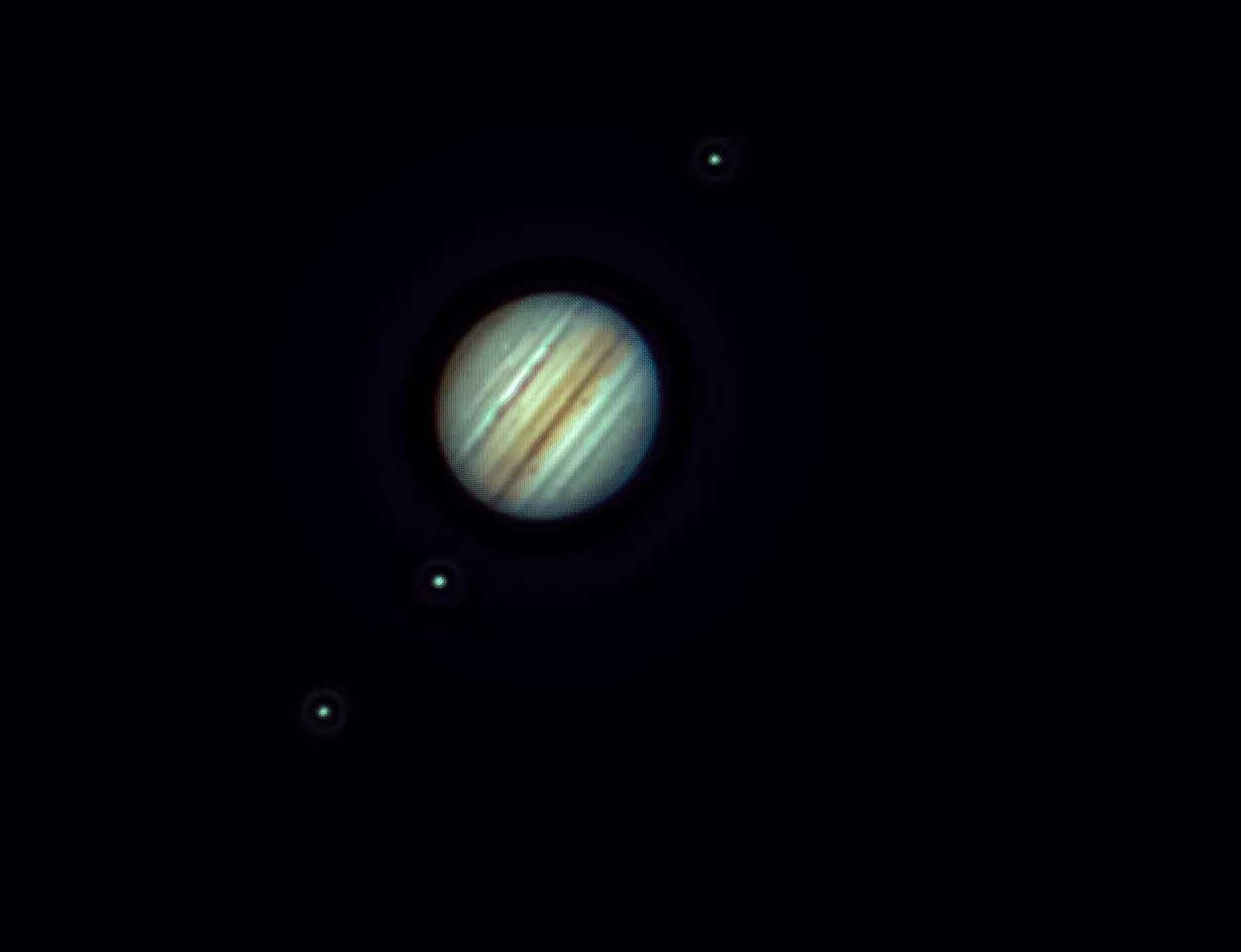 Jupiter with several visible moons against a black sky