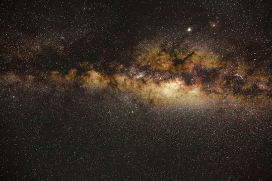 Dense Milky Way star field with golden dust lanes